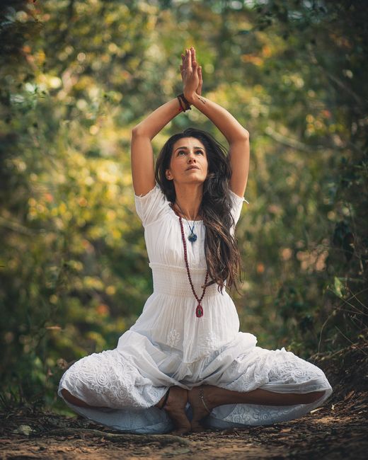 Woman meditating with chakras glowing in a peaceful environment