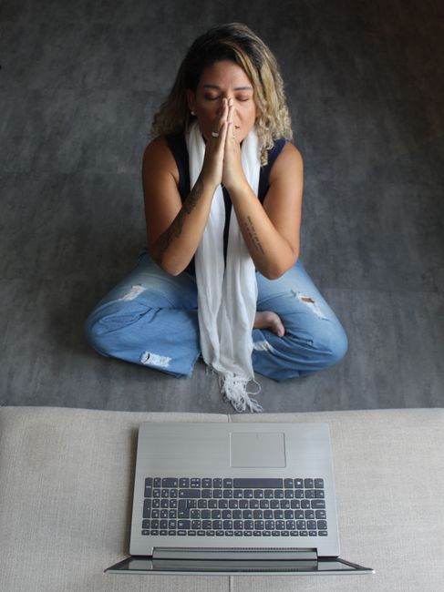 Person meditating with smartphone and headphones