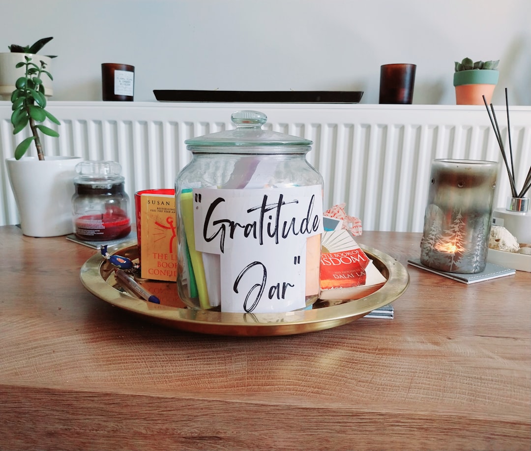 a jar filled with books on top of a wooden table