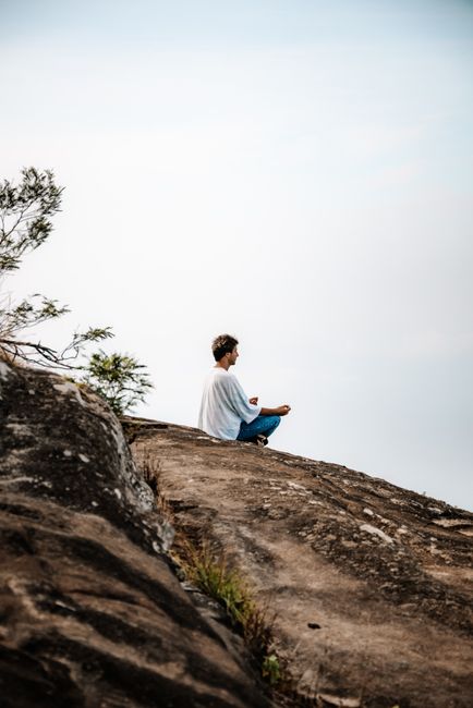 Person meditating in nature, serene atmosphere, mindfulness concept