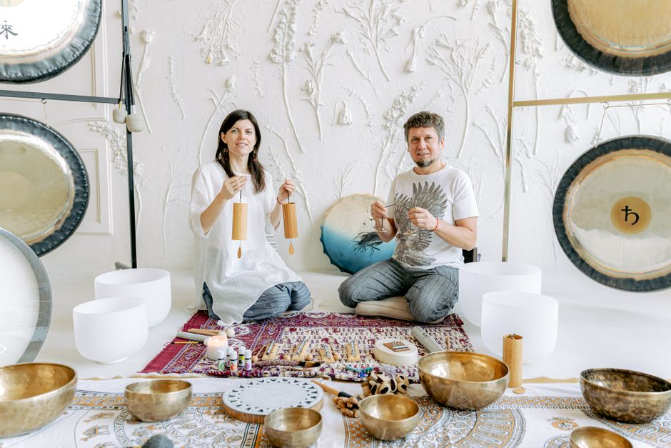Sound healing practitioner using singing bowls for chakra balance